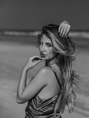 young beautiful woman model on the beach in a dress in a fashion photosoot