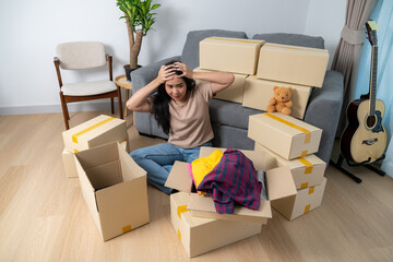 A tired young woman packing her belongings in boxes, preparing to move out