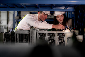 checking and inspecting metal machine part items for shipping. male and woman worker checking the...