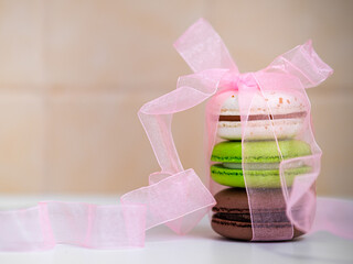 bright macaroon cookies with a decorative ribbon with a bow, sweet gift, card, print for a coffee shop