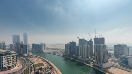 Obraz premium Modern city architecture in Business bay district before sunrise. Panoramic view of Dubai's skyscrapers all night timelapse