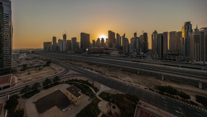 Obraz premium Dubai Marina skyscrapers and Sheikh Zayed road with metro railway aerial timelapse, United Arab Emirates