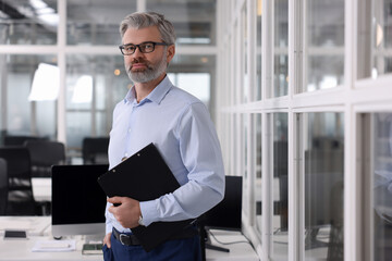 Fototapeta premium Handsome man with clipboard in office. Lawyer, businessman, accountant or manager