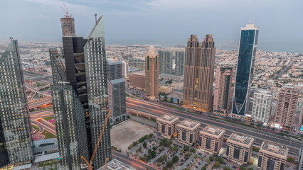 Fototapeta premium High-rise buildings on Sheikh Zayed Road in Dubai aerial night to day timelapse, UAE.