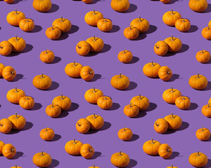 Isometric pattern with orange pumpkins on purple background