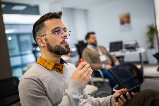 Young man smoking an electronic cigarette to quit tobacco. Vape man. Alternative nicotine-free smoking concept