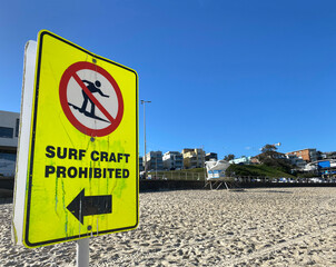 Warning sign on the beach indicating that surf craft is prohibited. Yellow panel to highlight a...