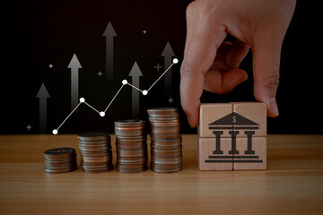 Coins stack with trading chart and wooden cube bank in financial concepts and financial investment...