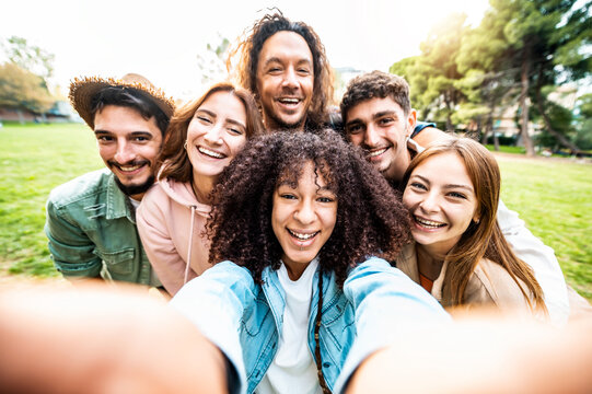 Multiracial friends taking selfie picture with smart mobile phone outside - Group of people smiling at camera outdoors a nature - Friendship concept with guys and girls enjoying wilde summer vacation
