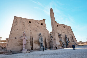 Seated statue of Ramesses II by the First pylon of the Luxor Temple, Egypt. Columns and statues of...