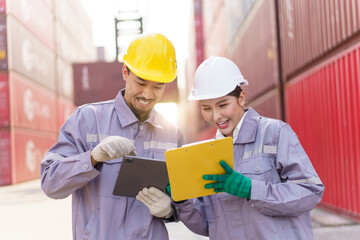 Smart and good looking Asian male and female container yard officers making a handshake together. Team of logistic engineer is working at the container yard.