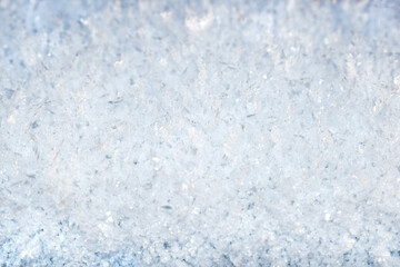 Fototapeta na wymiar Natural winter background of glittering snowflakes. Snow surface and texture. Copy space for text