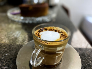 capuccino coffe cup in the foreground with blurry background