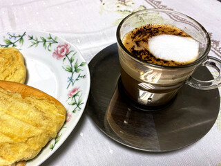 Capuccino coffe cup with tosted bread on the left on a saucer.