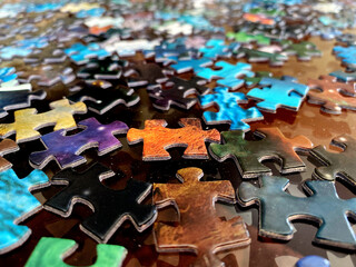 Scrambled colorful puzzle pieces over the table