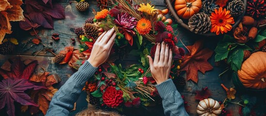 Naklejka premium Florist creating autumn wreath from above