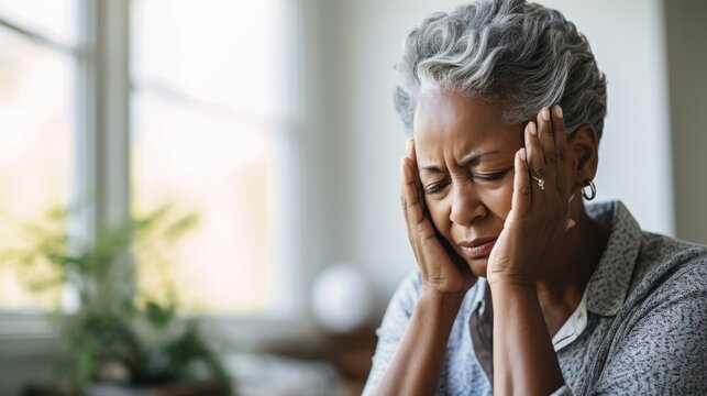 Elderly woman with a pained expression possibly depicting headache or distress