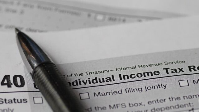 US Individual Tax Return Form 1040 and pen close-up rotation