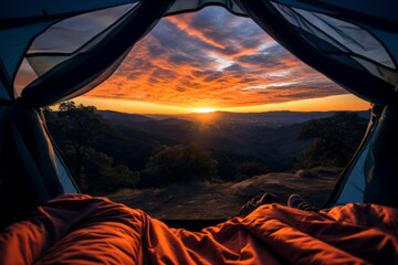 View from inside an open camping tent from the sleeping place to the beautiful mountains landscape at sunset. Concept of mountaineering, tourist recreation and sport