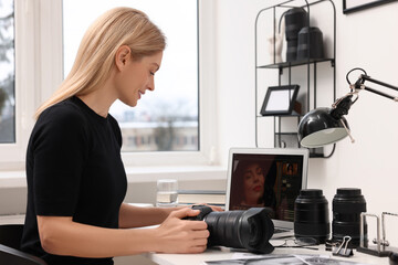 Professional photographer with digital camera at table in office