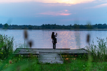 Fototapeta na wymiar Beautiful girl admiring incredible scenery on a picturesque lake....