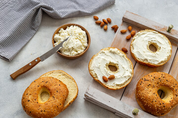 Fresh baked bagels with cream on board, top view. Healthy breakfast background