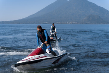 Two Young Hispanic Men Riding Jet-Skis in Atitlan Lake, Guatemala