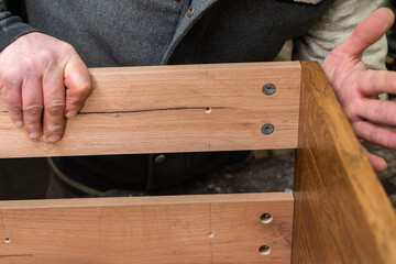The carpenter staples the cabinet details