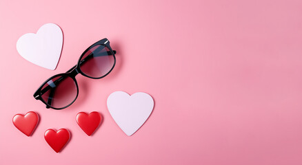 Sunglasses and heart shapes on a pink background. Place for text