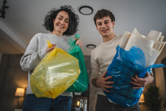 mother and son recycle at home sorting waste plastic paper and glass