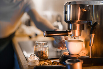 Preparing coffee. Espresso cup and machine. Kitchen interior.