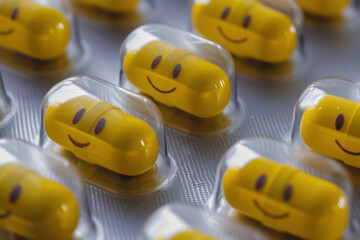Pill tablet packaging featuring vibrant yellow smiley face pills shaped like peapods