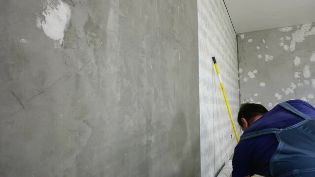A man in uniform glues wallpaper, Time lapse
