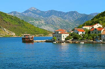 Fototapeta na wymiar Resort village on the shores of the Bay of Kotor at the foot of the mountains