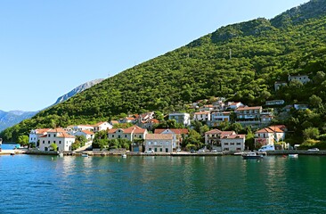 Fototapeta na wymiar Resort village on the shores of the Bay of Kotor at the foot of the mountains