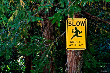 Traffic warning sign to “slow down” for sprinting adult’s with wine