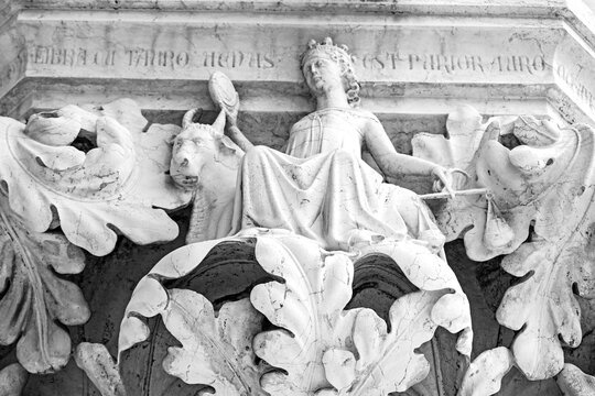 Venice, Italy, Sept. 17, 2023: Venus seated on a bull, holding balance scales and a mirror, symbolizes the zodiac sign Libra on a Doge’s Palace column capital sculpted in the 14th century.