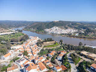 Fototapeta premium Aerial view of the border village of Alcoutim in Algarve, Portugal, with the Castle (Castelo de Alcoutim) on the banks of Guadiana river, with Sanlucar de Guadiana in the far view, Andalusia, Spain