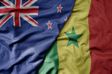 big waving national colorful flag of senegal and national flag of new zealand .