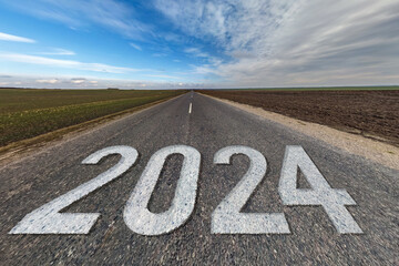 inscription 2023, 2024 and start on asphalt road highway with sunrise or sunset sky background.  concept of future, freedom, work start, run, planning, challenge, target, new year
