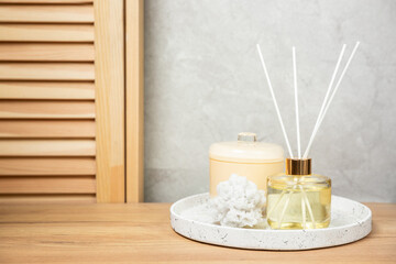 Green eucalyptus leaves in a vase stand on a chest of drawers against the background of a wall. Aromatherapy.Beautiful eucalyptus bouquet.Minimalist interior with flowers, candles and aroma diffuser.