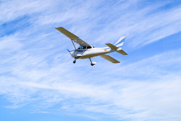 Fototapeta na wymiar Single engine ultralight plane flying in the blue sky with white clouds 