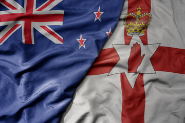 Fototapeta premium big waving national colorful flag of northern ireland and national flag of new zealand .