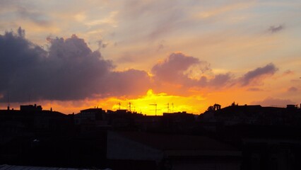 Skyline di una città con i colori infuocati del tramonto.