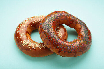 Fresh bread bagels with seed on blue background.