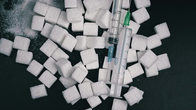 Sugar - drug, white sugar cubes and syringe. Sweets are harmful to health. Sugar addiction. Nutrition and diet control. Sugarless. Diabetes. Weight gain from sweets.