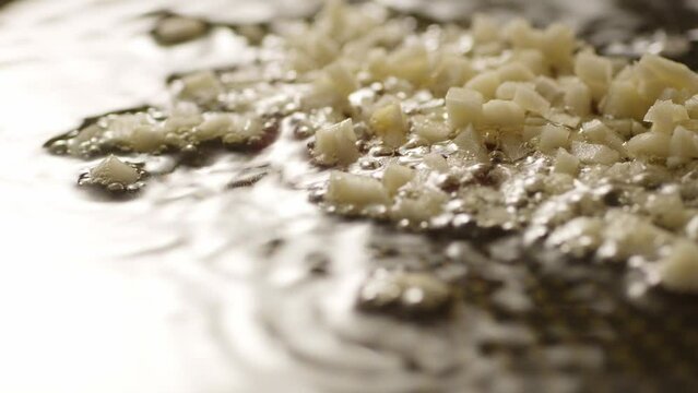 Sizzle garlic in oil in a pan. Step of Recipe Fried Assassin's Spaghetti Cooking. Close-up, shallow dof.
