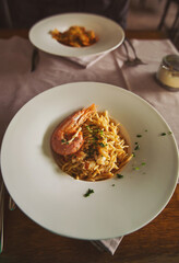Seafood pasta in a sauce with basil and parmesan in italian restaurant. Spaghetti with shrimps. Italian Traditional Dish