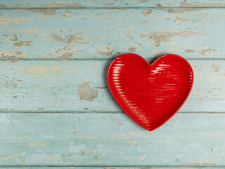 Heart shaped plate on vintage wooden background. Top view.