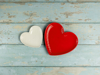 Heart shaped plates on vintage wooden background. Top view. - 728760748